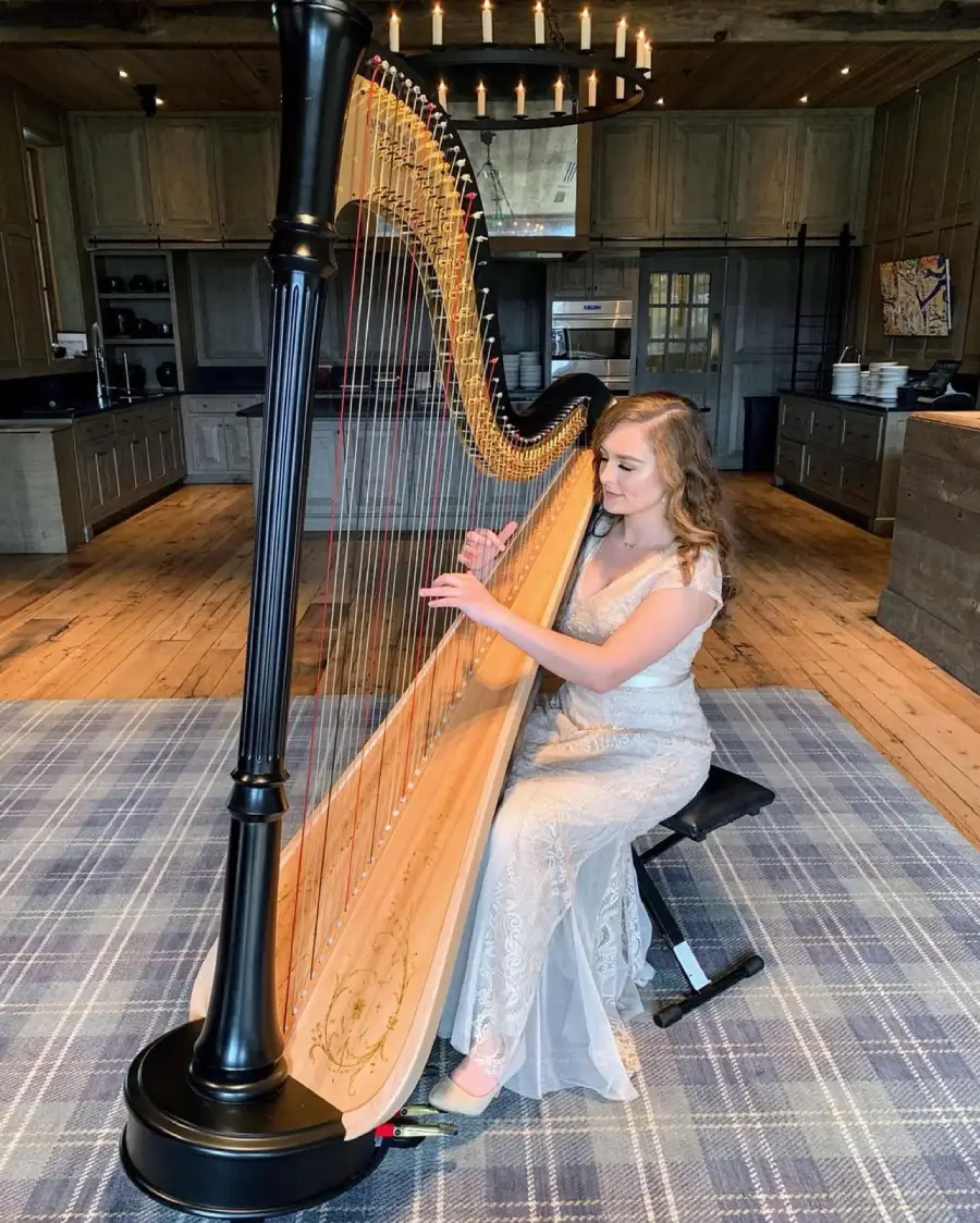 Korenna Hodge performing harp outdoors in elegant floral gown